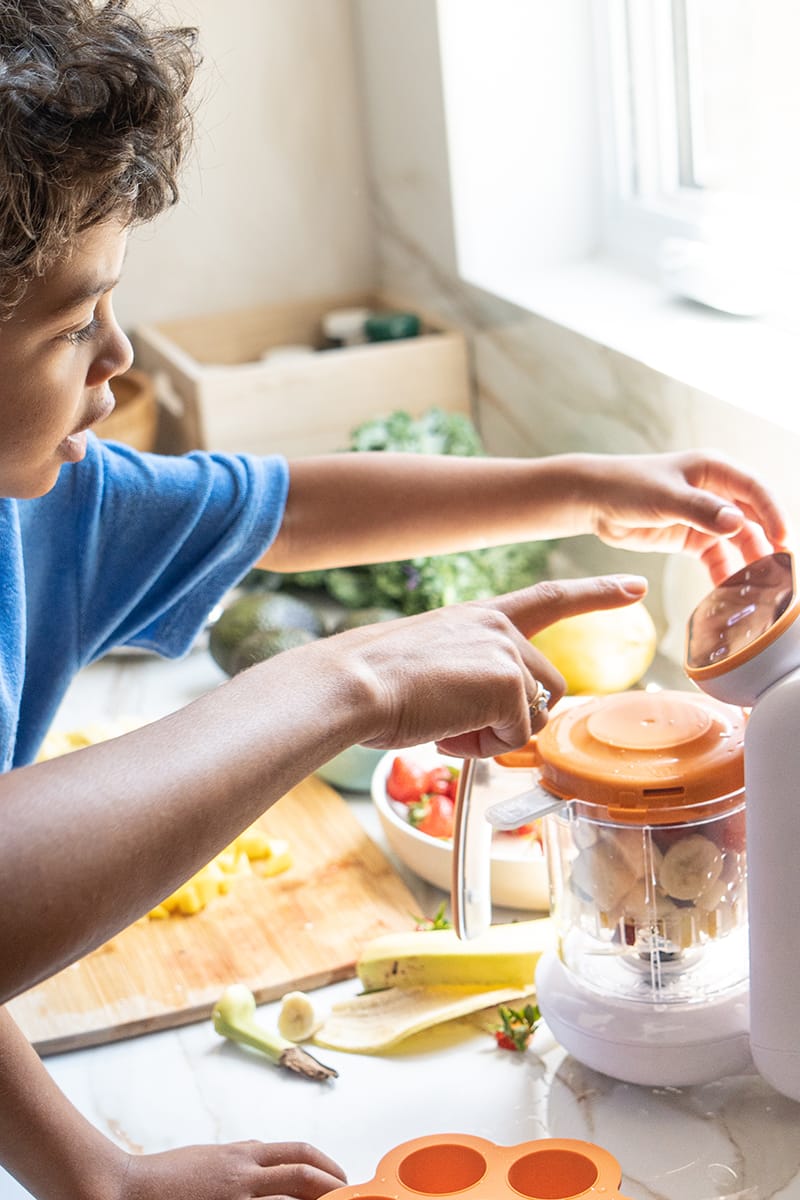 Child making food using a Quook baby food processor